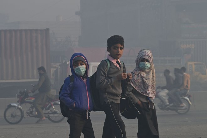 Afganistanski otroci hodijo v šolo med hudim smogom v Lahoreju. Foto: Arif Ali/Afp
