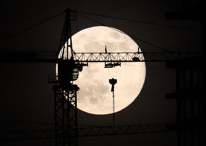 Zadnja polna luna v tem letu, znana kot mrzla luna, vzhaja za gradbiščem v Ankari. Foto: Adem Altan/Afp
