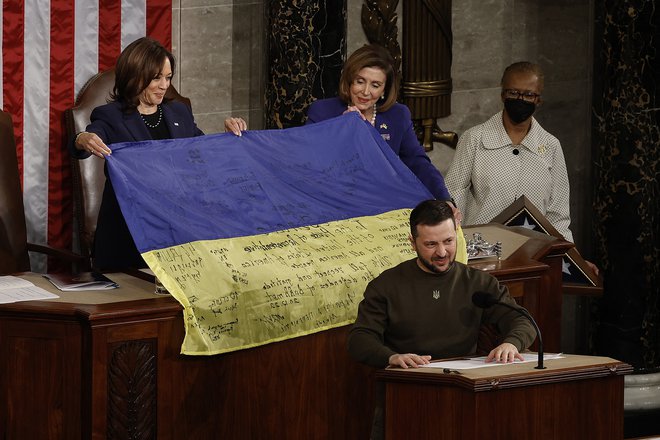 Med nastopom predsednika Volodimirja Zelenskega so v ameriškem kongresu razgrnili ukrajinsko zastavo s podpisi borcev proti ruski agresiji.

Foto Chip Somodevilla/AFP
