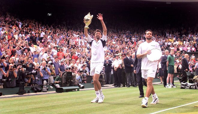 Goran Ivanišević in Patrick Rafter (desno) zapuščata wimbledonsko zelenico po nepozabnem finalu leta 2001. FOTO: Ian Waldie/Reuters
