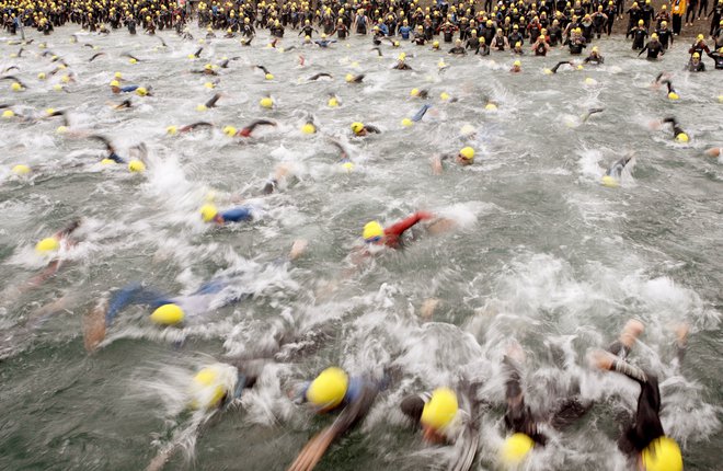 Ironman se začenja navsezgodaj zjutraj s plavanjem. FOTO: Arnd Wiegmann Reuters
