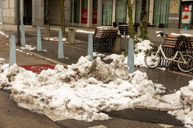 Kolesarski pas je priljubljeno mesto za odlaganje snega ... (poleti pa prostor za parkiranje). Na fotografiji sneg na kolesarski stezi 14. decembra 2021. FOTO ČRT PIKSI
