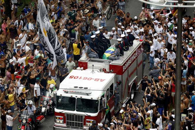 Pelejevo krsto, ki so jo prekrili z zastavama Santosa in Brazilije, so&nbsp;s stadiona odpeljali na gasilskem tovornjaku. FOTO:&nbsp;Amanda Perobelli /Reuters
