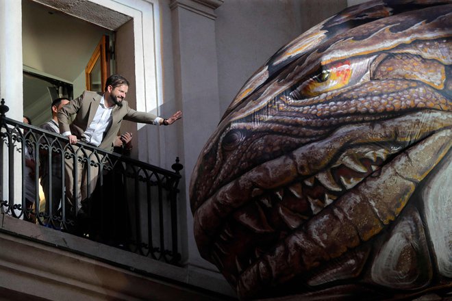 Čilski predsednik Gabriel Boric se je želel dotaknti napihljivega dinozavra Sauriana, ki je del &raquo;Saurian in priče iz vesolja&laquo; - nočne parade na otvoritveni dan mednarodnega festivala &raquo;Teatro a Mil&laquo; pred predsedniško palačo La Moneda v Santiagu. Foto: Javier Torres/Afp
