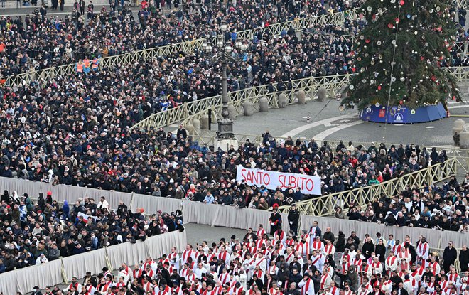 Med verniki na trgu pred baziliko je bilo po podatkih vatikanskega urada zelo veliko nemških. Videti je bilo tudi transparente z napisom: Svetnik takoj! FOTO: Alberto Pizzoli/AFP
