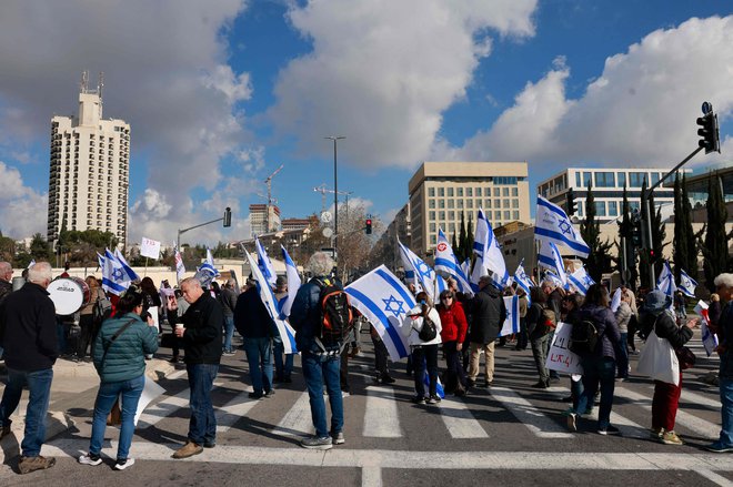 Protest pred izraelskim vrhovnim sodiščem, kjer je ta teden potekala razprava o tem, ali lahko v Netanjuhujevem kabinetu služi tudi eden od njegovih tesnih zaveznikov, ki je bil lani obsojen zaradi davčne utaje. Foto: Menahem Kahana/AFP
