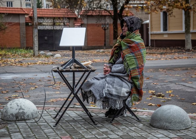 Starlinkov sprejemnik v ukrajinskem Hersonu konec novembra lani. Foto Stringer/Reuters
