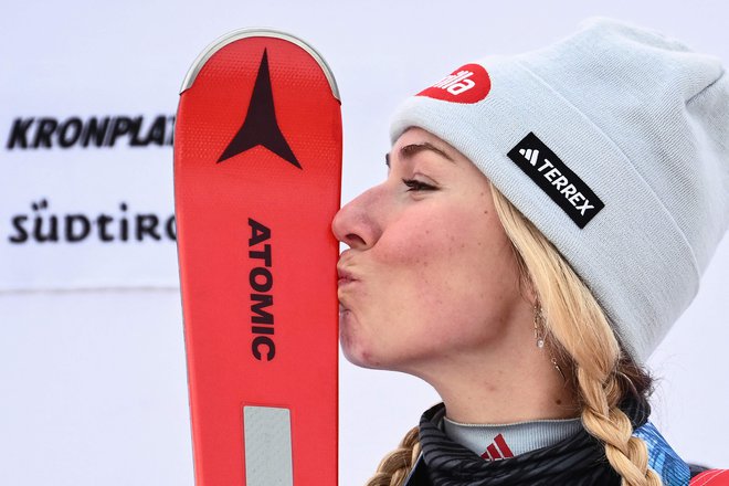 Mikaela Shiffrin je po novem podvigu poljubila svoje zmagovite smuči. FOTO: Marco Bertorello/AFP
