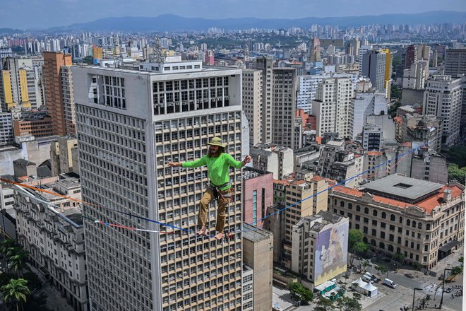 Brazilski vrvohodec Rafael Bridi je v okviru 469. obletnice mesta Sao Paulo na 114 metrih višine po vrvi prečkal celotno 510 metrov dolgo območje Vale do Anhangabau. Bridi je po podatkih mednarodnega združenja za &raquo;slackline&laquo; podrl svoj lastni rekord na urbani razdalji. Foto: Nelson Almeida/Afp
