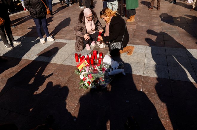 Dan po napadu 25-letnega maroškega osumljenca na vernike v cerkvah&nbsp;v Algecirasu v Španiji so ženske na mesto napada položile cvetje in prižgale sveče. FOTO: Marcelo Del Pozo/Reuters
