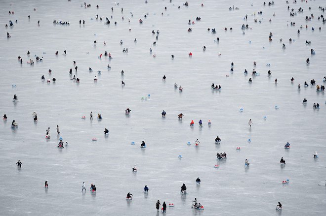 Ljudje se sankajo na zamrznjenem jezeru ob Poletni palači v Pekingu. Foto: Wang Zhao/Afp
