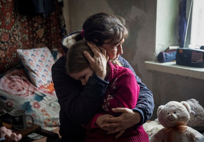 Babica Olha objema svojo šestletno vnukinjo Arino ob slovesu pred evakuacijo iz mesta Bakhmut na frontni črti v ukrajinski regiji Doneck. Foto: Stringer/Reuters
