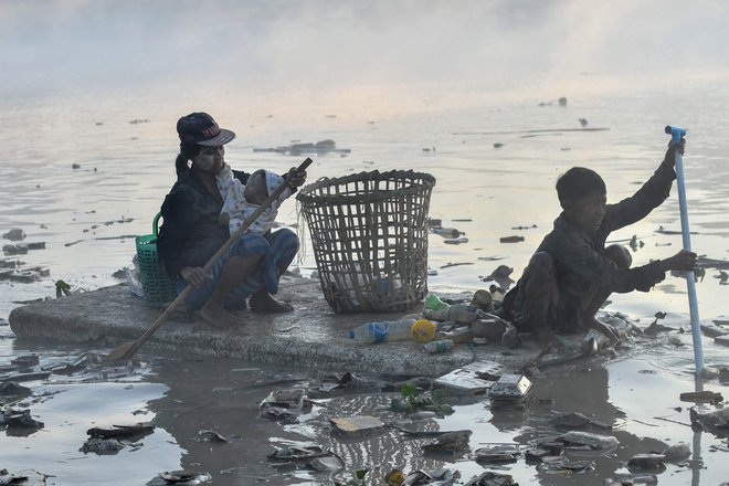 Zbiralci odpadkov s čolni iz polistirena iščejo plastiko in steklo za recikliranje v reki Pazundaung v Jangonu.&nbsp; Na desetine burmarskih zbiralcev odpadkov se je podalo v mračne vode reke v Jangonu, potem ko jih je gospodarska kriza po državnem udaru prignala do iskanja dela. Foto: Sai Aung Main/Afp
