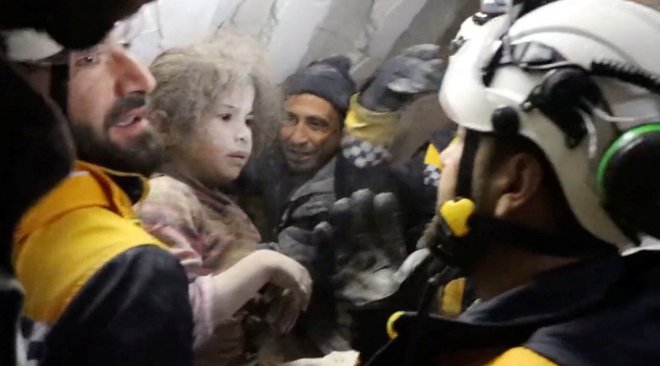 Pripadniki Belih čelad pomagajo preživeli sirski deklici. FOTO: White Helmets via Reuters
