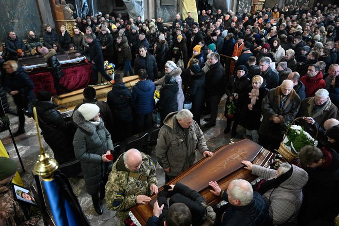 V mestih in vaseh zahodne Ukrajine tako rekoč ves čas potekajo pogrebi ubitih vojakov. FOTO: Yuriy Dyachyshyn/AFP
