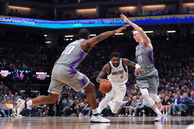 Kyrie Irving (z žogo) prodira med Kevinom Huerterjem (desno)&nbsp;in nekdanjim članom Dallasa Harrisonom Barnesom v drugi četrtini tekme v Kaliforniji.&nbsp;FOTO:&nbsp;Cary Edmondson/USA&nbsp;Today Sports
