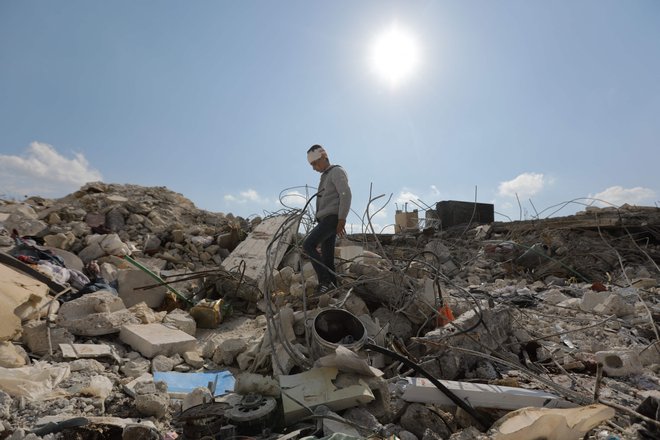 Deček med ruševinami družinske hiše v sirskem mestu Jindajris v provinci Alep, ki je pod nadzorom upornikov. FOTO: Bakr Alkasem/Afp
