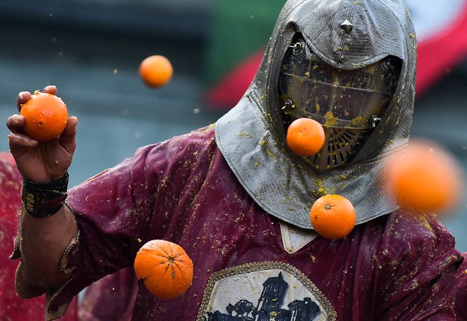 V mestu Ivrea je potekala vsakoletna bitka s pomarančami. Vsako leto se več tisoč ljudi zbere na ulicah italijanskega mesteca v severni Italiji, kjer se obmetavajo s pomarančami v okviru vsakoletne Bitke pomaranč. Letos v mesto iz Sicilije uvozili več kot 500 ton pomaranč, ki naj bi jih porabili med dogodkom. Bitka je del večjega dogodka, ki se imenuje ivreški karneval. Foto: Massimo Pinca/Reuters
