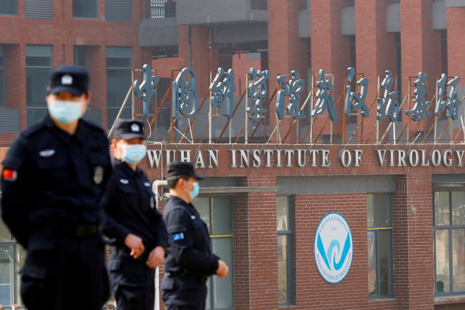 Varnostniki pred wuhanskim Inštitutomza virologijo ob obisku delegacije WHO februarja 2021. FOTO: Thomas Peter/Reuters
