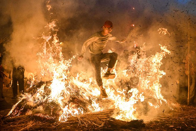 Moški skače čez ogenj, da bi se po starem običaju znebil nesreče v mestu Jieyang v južni kitajski provinci Guangdong. Foto: Stringer/Afp
