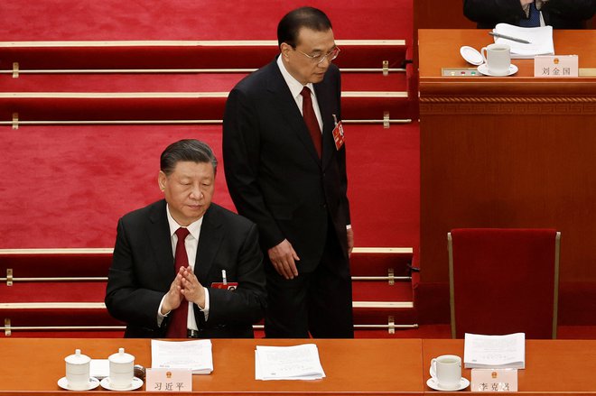 Predsednik kitajske vlade Li Keqiang se po govoru poslancem v kongresu vrača v klop poleg predsednika Xi Jinpinga. FOTO: Thomas Peter/Reuters

