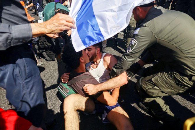 V Tel Avivu so se izraelski policisti spopadli z demonstrantoma, ki sta se poljubljala med dnevom upora, ko nacionalistična koalicijska vlada izraelskega premiera Benjamina Netanjahuja nadaljuje s sporno prenovo pravosodja. Foto: Ronen Zvulun/Reuters
