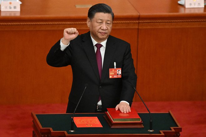 Xi Jinping je levo roko položil na ustavo z rdečimi platnicami in v zlatu odtisnjenimi pismenkami, desnico pa dvignil v zrak ter prisegel kot najdlje vladajoči kitajski voditelj od smrti Mao Zedonga leta 1976. FOTO: Noel Celis/AFP
