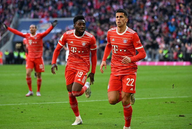 Joao Cancelo in Alphonso Davies sta takole proslavila enega od golov Bayerna. FOTO: Angelika Warmuth/Reuters
