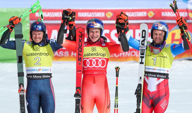 Marco Odermatt (v sredini) proslavlja drugo zmago v dveh dneh v Podkorenu ob Norvežanu Henriku Kristoffersnu (levo) in Francozu Alexisu Pinturaultu.&nbsp;FOTO: Matej Družnik/Delo
