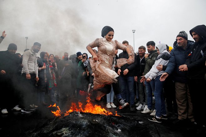 Ženska skače čez ogenj v Istanbulu med praznovanjem praznika Nowruz, ki zaznamuje prihod pomladi. Foto: Dilara Senkaya/Reuters
