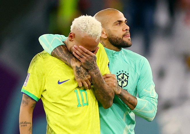 Dani Alves (desno) je 9. decembra lani tolažil rojaka Neymarja po usodnem porazu s Hrvaško na SP. FOTO: Matthew Childs/Reuters