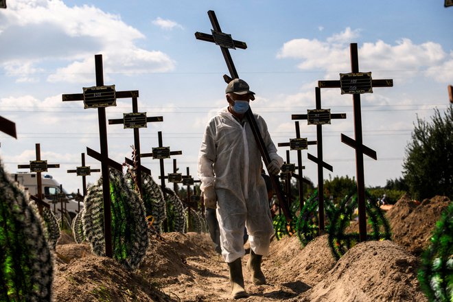 Žrtve obleganja so pokopane na pokopališču v Buči, nekaterih med njimi preiskovalcem ni uspelo identificirati. FOTO: Vladyslav Musiienko/Reuters