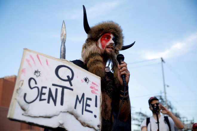 Vzdevek samooklicanega šamana se nanaša na teorijo zarote, katere privrženci menijo, da je nekdanji predsednik Trump vodil skrivno vojno proti elitnim pedofilom, ki častijo satana. FOTO: Cheney Orr/Reuters