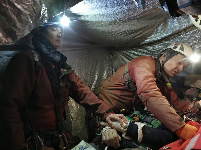 Zdravnica Tina Bizjak in zdravstveni tehnik Samo Milanič ob poškodovani jamarki v Vranjedolski jami. FOTO: Damijan Šinigoj

 

 