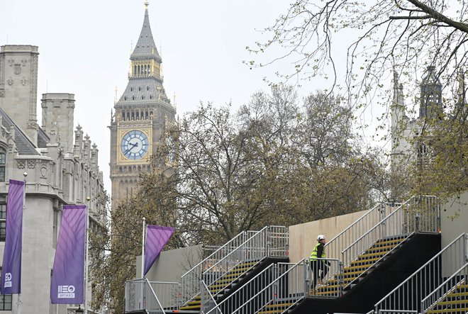 V Londonu potekajo še zadnje priprave. Westminstrska opatija je že zaprta za javnost, v njeni bližini pa so postavili tribune za ogled kraljeve procesije. FOTO: Toby Melville/ Reuters