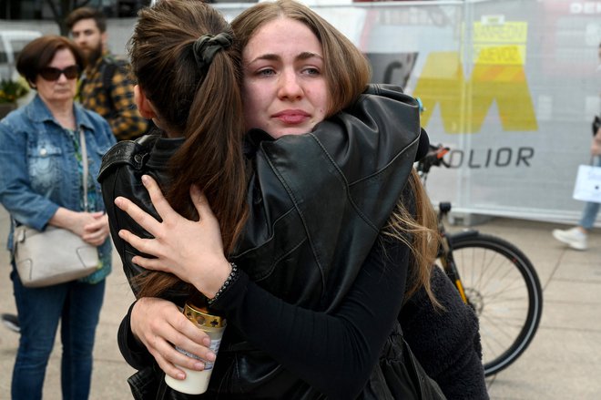 Ljudje ob spomeniku Petru Preradoviću na Cvetnem trgu v Zagrebu prižigajo sveče. FOTO: Denis Lovrovic/AFP