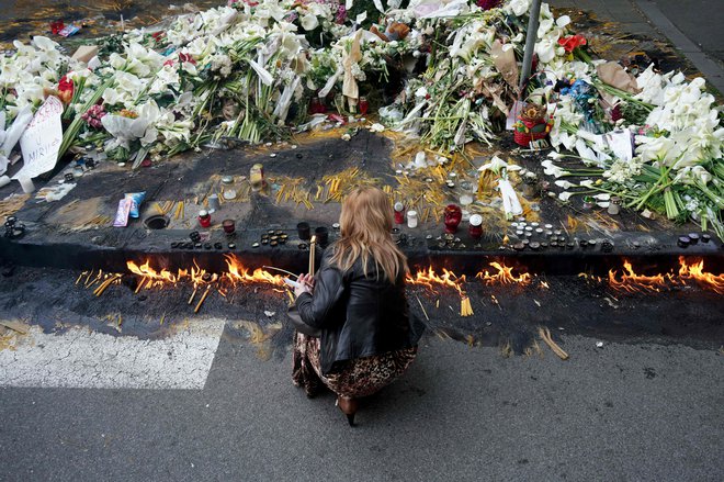 Pred šolo Vladislava Ribnikarja so šopki rož in sveče v spomin na tragedijo. FOTO: Oliver Bunic/AFP