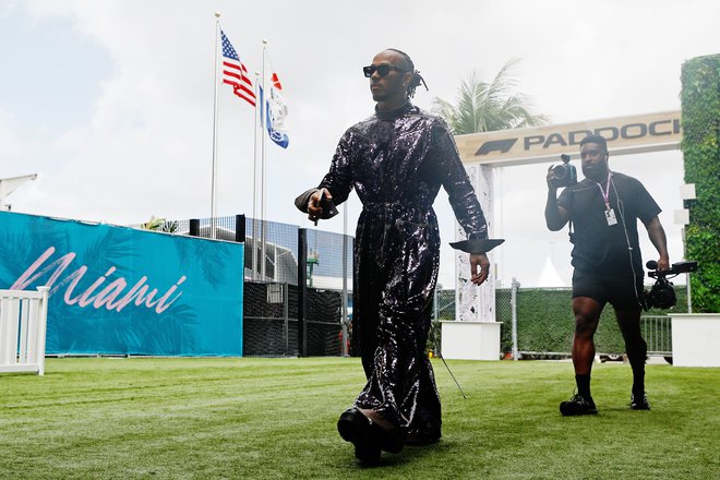 Lewis Hamilton je pred dirko poziral v vijoličastem kostumu. FOTO: Chris Graythen/AFP