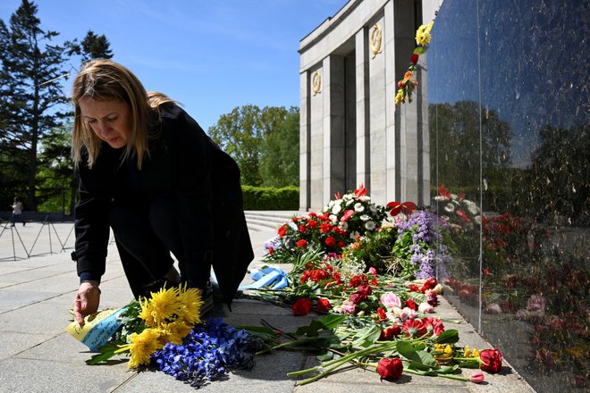 Pred sovjetskim spomenikom v Berlinu so obiskovalci polagali cvetje, ovito v rumeno-modre barve ukrajinske zastave. FOTO: Annegret Hilse/REUTERS