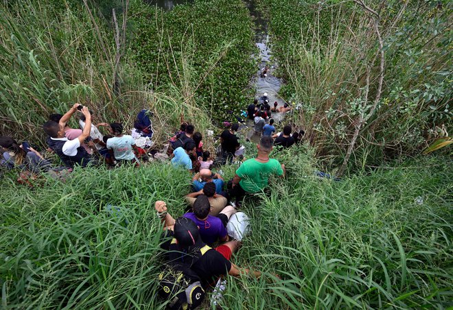Migranti v Matamorosu prečkajo mejno reko z ZDA, Rio Bravo. Pred koncem omejitev, ki jim pravijo tudi člen 42, ki so veljale med pandemijo covida-19., po ocenah na mehiški strani v nizkem startu čaka milijon ljudi – da bi se pridružili milijonom, ki naj bi v času Bidnove vladavine nezakonito prečkali mejo. Foto: Alfredo Estrella/Afp