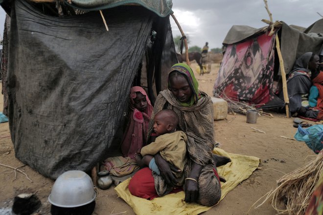 30-letna Mekka, sudanska begunka, ki je pobegnila pred nasiljem v sudanski regiji Darfur, sedi s svojimi otroki v začasnem zavetišču blizu meje med Sudanom in Čadom. Foto: Zohra Bensemra/Reuters