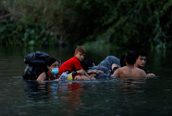 Migranti vstopijo v reko Rio Bravo, da bi prečkali mejo in se pred iztekom naslova 42 predali agentom ameriške mejne patrulje v Matamorosu v Mehiki, 10. maja 2023. Foto Daniel Becerril Reuters