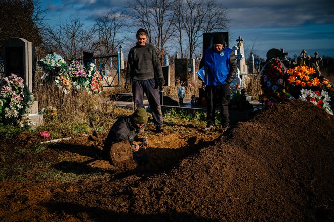 Preiskovalci vojnih zločinov so na pokopališču v bližini Hersona decembra lani prisostvovali izkopu posmrtnih ostankov 58-letne Ukrajinke, ubite med rusko invazijo. FOTO: Dimitar Dilkoff/Afp