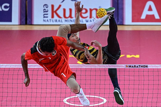 Malezijec Muhammad Noraizat Mohd Nordin (R) in Indonezijec Saiful Rijal (L) tekmujeta v finalu dvojnega sepak takrawa med 32. igrami Jugovzhodne Azije v Phnom Penhu. Foto: Mohd Rasfan/Afp