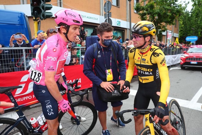 Primož Roglič (desno) je Geraintu Thomasu v cilju 11. etape pokazal bojne rane po padcu, v katerega sta se zapletla 69 km pred ciljem. Foto Luca Bettini/AFP