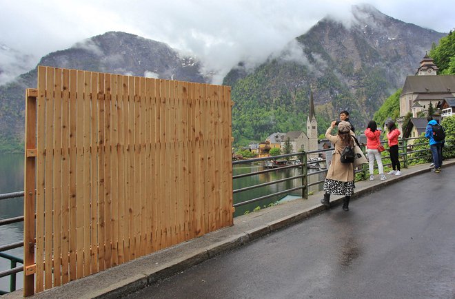 Lesena pregrada, ki je stala le nekaj dni, naj bi turistom preprečila najlepši razgled in jih opomnila, da tu ljudje tudi živijo, ne le dopustujejo. FOTO: Afp/austria Out Afp