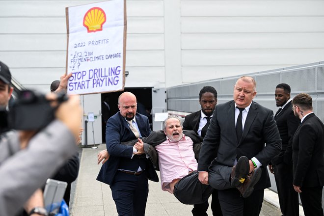 Varnostniki odstranijo protestnika med demonstracijami Fossil Free London pred prizoriščem letnega srečanja delničarjev družbe Shell v centru ExCeL v Londonu. Foto: Toby Melville/Reuters