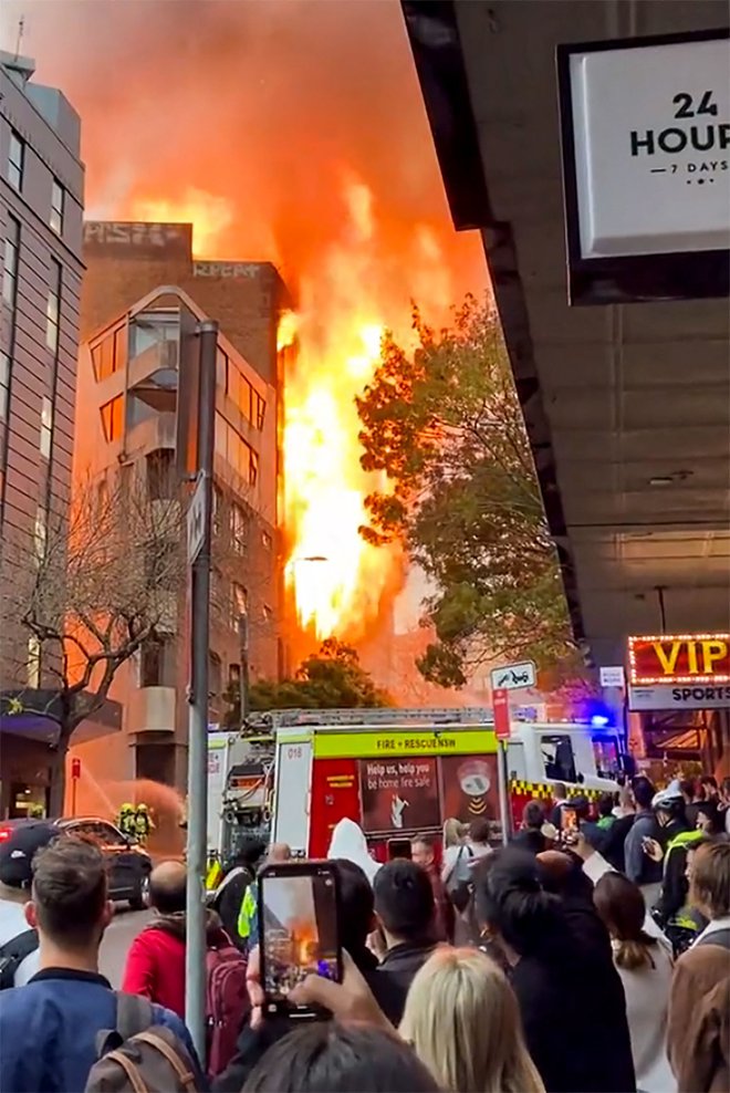 Na družbenih omrežjih so zaokrožili posnetki plamenov, ki so se valili iz oken večnadstropne stavbe. FOTO: Grant Ozolins/Twitter/AFP