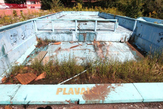 Namesto vode v vevškem kopališču raste plevel. In tako bo vsaj še tri leta, dokler ne bodo uredili odprtega kopališča in športnega kompleksa. FOTO: Dejan Javornik/Delo