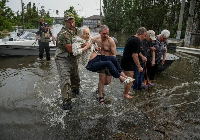 Po kolapsu na jezu rešujejo, kogar in kar se rešiti da ... FOTO: Stringer Reuters